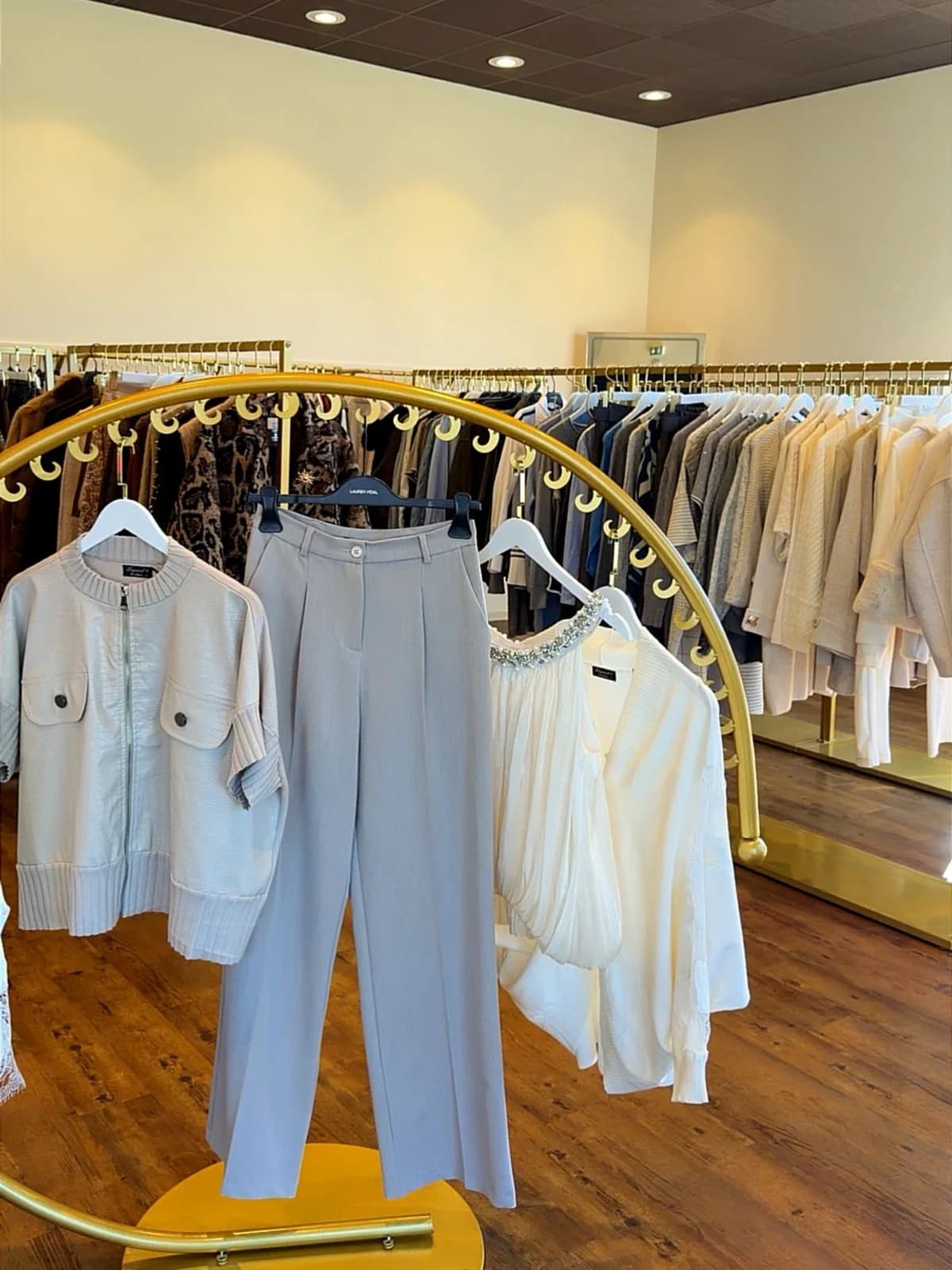 Le portant circulaire doré de la boutique 1Tempor'ELLE, avec une tenue composée en tons clairs