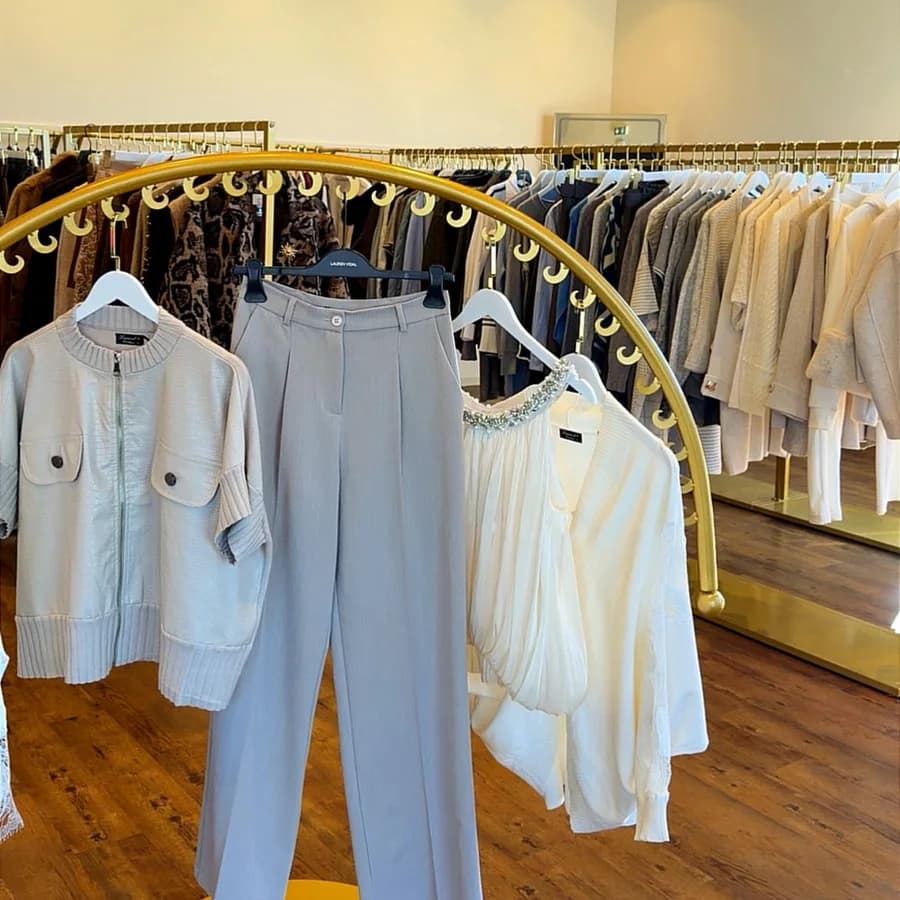 Le portant circulaire doré de la boutique 1Tempor'ELLE, avec une tenue composée en tons clairs