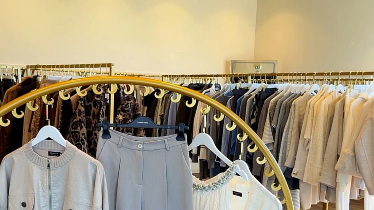 Le portant circulaire doré de la boutique 1Tempor'ELLE, avec une tenue composée en tons clairs